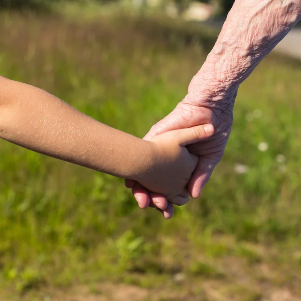 Hands of old woman and child — Stock Photo, Image