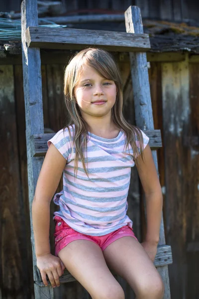 Kleines Mädchen in der Nähe eines Landhauses. — Stockfoto