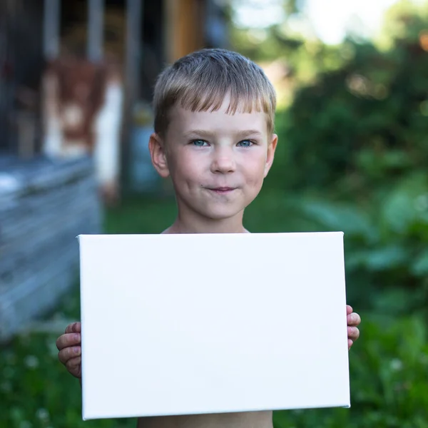 Boy holding clean sheet paper — Stock Photo, Image