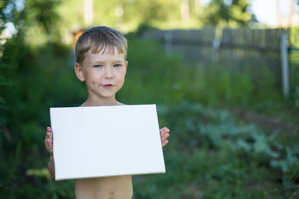 Маленький мальчик держит чистую бумагу — стоковое фото
