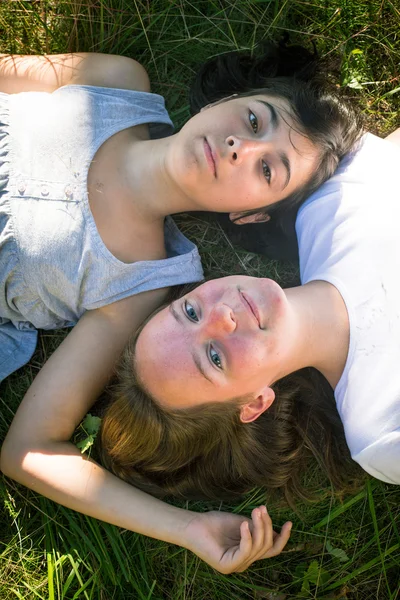 Twee jonge meisje liggen op gras — Stockfoto