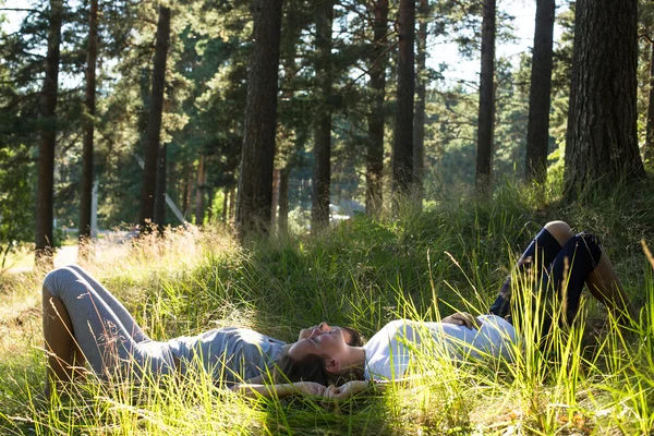 Två unga flickan liggande på gräs — Stockfoto