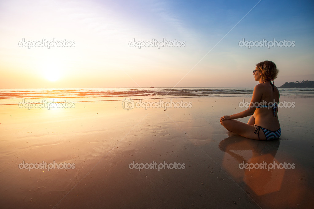 Yoga woman sitting on sea coast