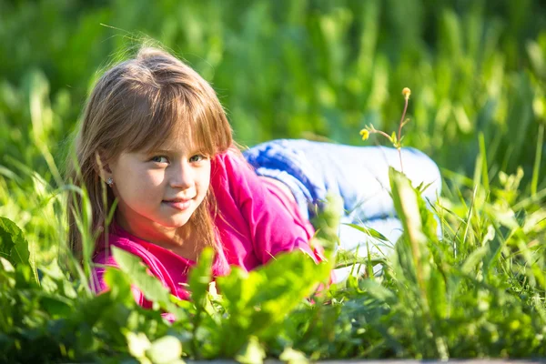 Meisje liggend in het gras. — Stockfoto