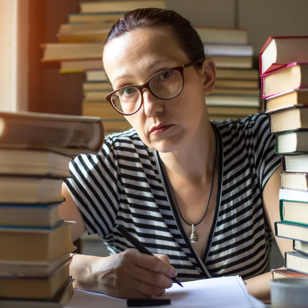 Vrouw in een kamer met een heleboel boeken — Stockfoto