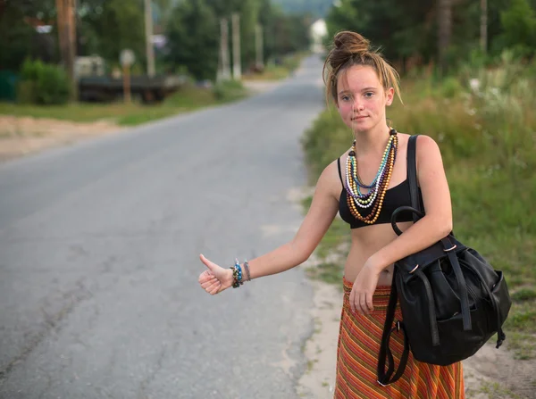 Girl  hitchhiking on countryside road. — Stock Photo, Image