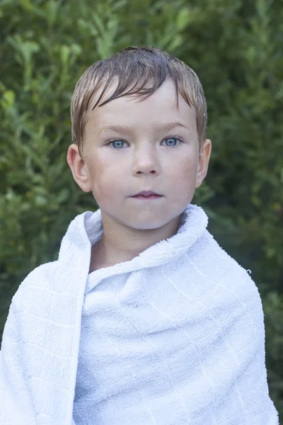 Little boy wrapped in a towel after swimming — Stock Photo, Image
