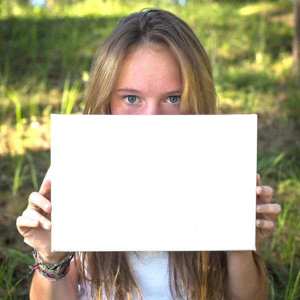 Menina segurando papel branco limpo folha — Fotografia de Stock