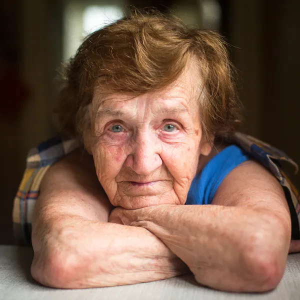 Masada oturan yaşlı kadın — Stok fotoğraf