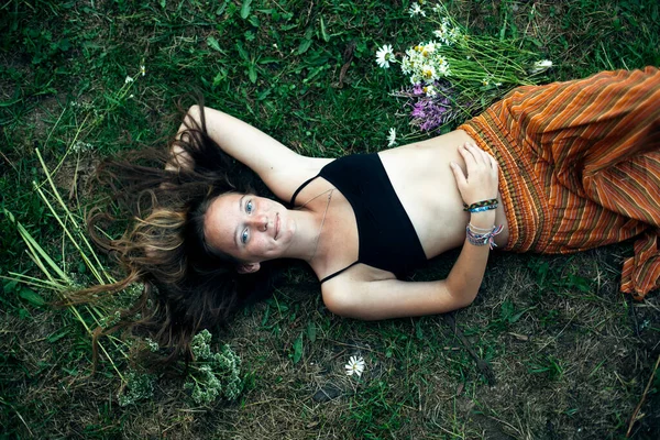 一个女孩的头像躺在村里的绿草上 — 图库照片