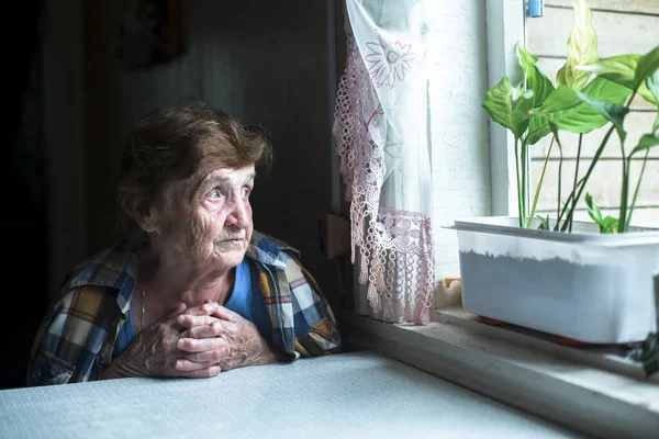 Una Anciana Solitaria Está Sentada Junto Ventana Casa —  Fotos de Stock