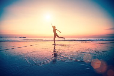 Gün batımında sahilde bir kadın.