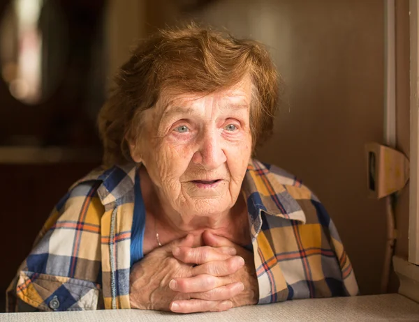 Пожилая женщина сидит и разговаривает в доме — стоковое фото