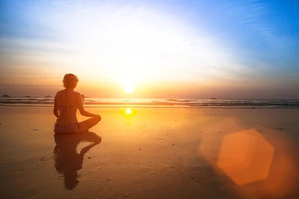 Vrouw die yoga beoefent aan zee — Stockfoto