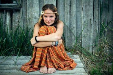 Hippi elbiseli bir kız köyün dışında tek başına oturuyor.. 