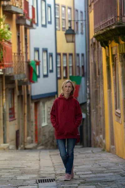 パーカーを着た女性が古いポルトガルの町を歩いている — ストック写真
