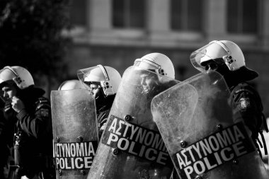 ATİNA, GREECE - 15 Nisan 2015: Protestocu solcu ve anarşist grupların işgal ettiği Atina Üniversitesi önünde düzenlenen bir protesto sırasında çevik kuvvet ve protestocular. Siyah-beyaz çekim raporu..