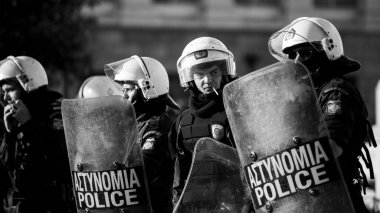 ATİNA, GREECE - 15 Nisan 2015: Protestocu solcu ve anarşist grupların işgal ettiği Atina Üniversitesi önünde düzenlenen bir protesto sırasında çevik kuvvet ve protestocular. Siyah beyaz fotoğraf..