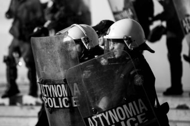 ATİNA, GREECE - 15 Nisan 2015: Protestocu solcu ve anarşist grupların işgal ettiği Atina Üniversitesi önünde düzenlenen bir protesto sırasında çevik kuvvet ve protestocular. Siyah beyaz fotoğraf..