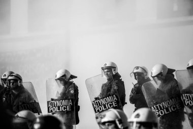 ATİNA, GREECE - 15 Nisan 2015: Protestocu solcu ve anarşist grupların işgal ettiği Atina Üniversitesi önünde düzenlenen bir protesto sırasında çevik kuvvet ve protestocular. Siyah-beyaz çekim raporu..