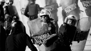 ATİNA, GREECE - 15 Nisan 2015: Protestocu solcu ve anarşist grupların işgal ettiği Atina Üniversitesi önünde düzenlenen bir protesto sırasında çevik kuvvet ve protestocular. Siyah beyaz fotoğraf..