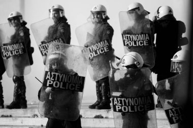 ATİNA, GREECE - 15 Nisan 2015: Protestocu solcu ve anarşist grupların işgal ettiği Atina Üniversitesi önünde düzenlenen bir protesto sırasında çevik kuvvet ve protestocular. Siyah beyaz fotoğraf..