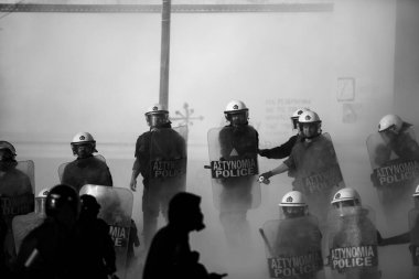 ATİNA, GREECE - 15 Nisan 2015: Protestocu solcu ve anarşist grupların işgal ettiği Atina Üniversitesi önünde düzenlenen bir protesto sırasında çevik kuvvet ve protestocular. Siyah beyaz fotoğraf..