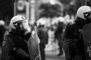 ATİNA, GREECE - 15 Nisan 2015: Protestocu solcu ve anarşist grupların işgal ettiği Atina Üniversitesi önünde düzenlenen bir protesto sırasında çevik kuvvet ve protestocular. Siyah beyaz fotoğraf..