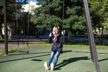 Parkta sallanan bir kadın..