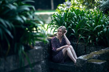 Porto, Portekiz 'deki eski bir parkta, yeşilliklerin arasında bir kadın oturuyor..