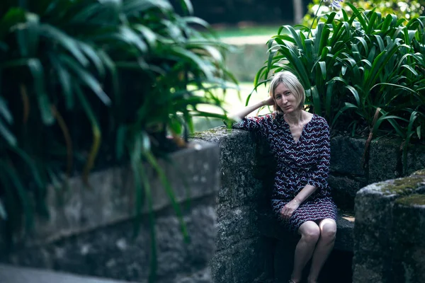 Porto, Portekiz 'deki eski bir parktaki yeşillikler arasında bir kadın..