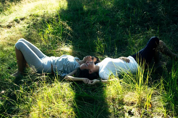 Genç Kız Arkadaşlar Bir Yaz Parkında Yeşil Çimlerin Üzerinde Yatıyorlar — Stok fotoğraf