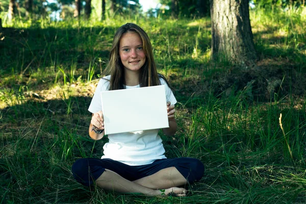 Dívka Držící Čistý Bílý List Papíru Banner Pro Zprávu Zeleném — Stock fotografie