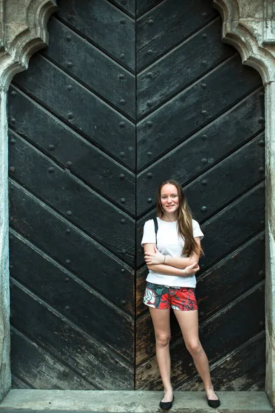 Nastolatka Stoi Pobliżu Starożytnych Masywnych Drewnianych Drzwi — Zdjęcie stockowe