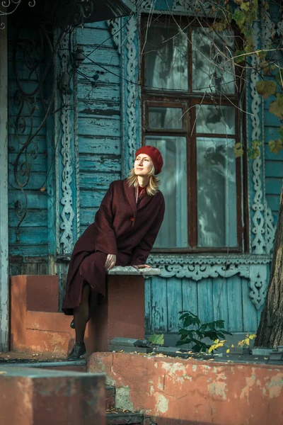 Eine Frau Weinroten Mantel Sitzt Auf Der Veranda Eines Alten — Stockfoto