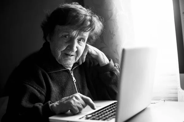 自宅でパソコンを勉強している老婆 白黒写真 ロイヤリティフリーのストック画像
