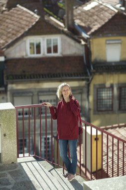 Kapüşonlu bir kadın eski bir Portekiz şehrinde geziniyor..
