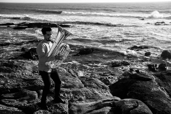 海沿いにチューバを持ったミュージシャン 白黒写真 — ストック写真