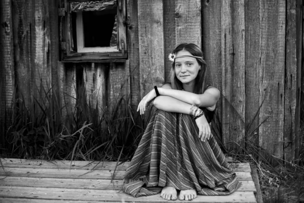 田舎の女の子が家の庭に座っている 白黒写真 — ストック写真