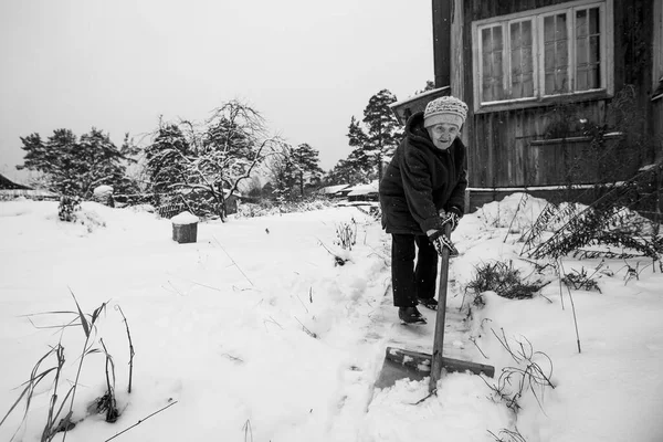 Yaşlı Bir Kadın Kırsal Evinin Dışında Kar Kürüyor Siyah Beyaz Telifsiz Stok Fotoğraflar