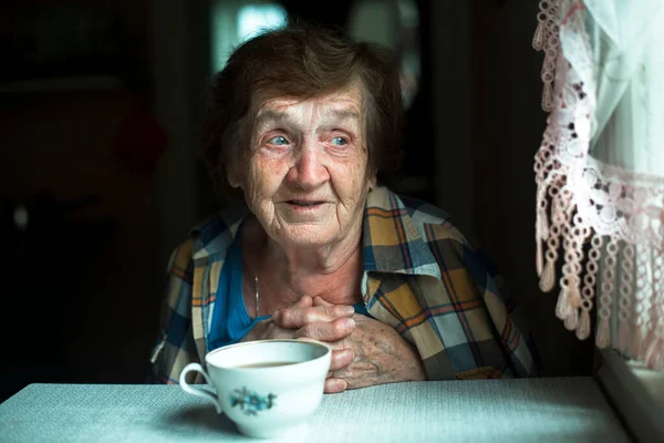 Mirada Sonrisa Una Anciana Sobre Fondo Oscuro Cerca Una Ventana —  Fotos de Stock