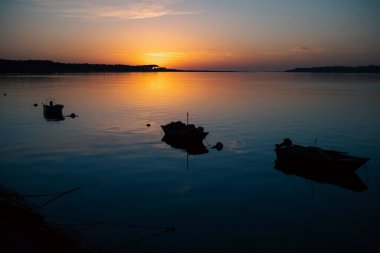 İnanılmaz günbatımında Minho Nehri manzarası, Portekiz ve İspanya arasındaki sınırda balıkçı tekneleri siluetleri.