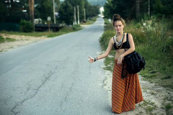 Uma Hippie Carona Menina Está Votando Uma Estrada Campo — Fotografia de Stock