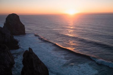 Portekiz 'de Cabo Da Roca yakınlarındaki Atlantik kıyısında gün batımında kayaların manzarası..