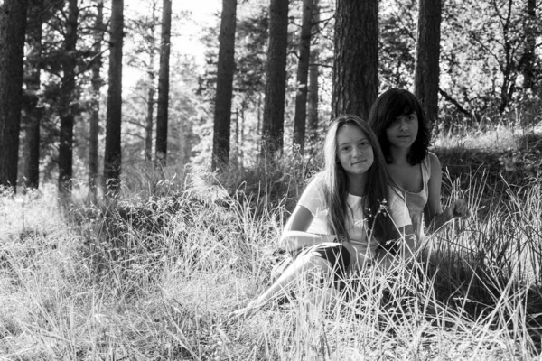 Dwie Nastoletnie Siostry Siedzą Latem Trawie Parku Czarno Białe Zdjęcie — Zdjęcie stockowe