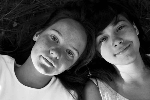 2人の女の子の上からの肖像画は 草の上に横たわっていた 白黒写真 — ストック写真