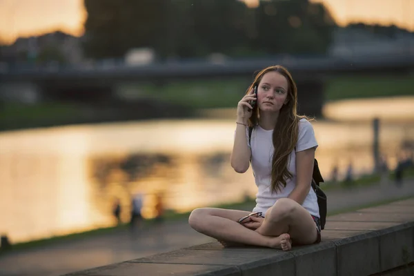 Teengerka Mluví Mobilu Zatímco Sedí Nábřeží Města — Stock fotografie