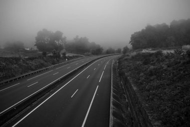Sisin içinde boş bir otoyol. Siyah beyaz fotoğraf.