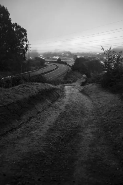 高速道路の隣の田舎道 白黒写真 ロイヤリティフリーのストック写真