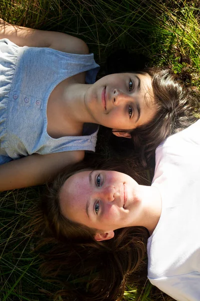 Two Teenage Girl Lying Green Grass Having Good Time ロイヤリティフリーのストック画像